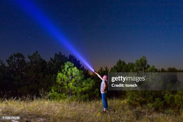a tourist shining a flashlight at night - using flashlight stock pictures, royalty-free photos & images