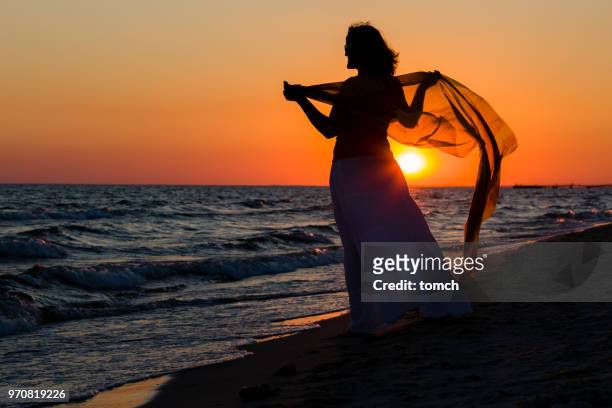 pôr do sol laranja e uma senhora solitária com o lenço - língua de areia - fotografias e filmes do acervo
