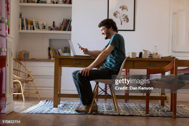 man in kitchen using laptop - dan kenyon bildbanksfoton och bilder
