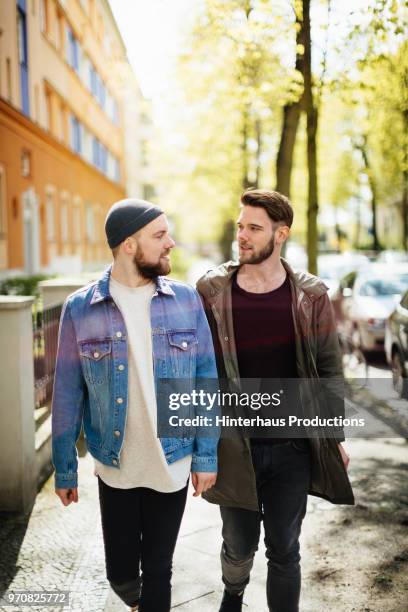 stylish gay couple out walking together - pulsante di apertura o di chiusura foto e immagini stock