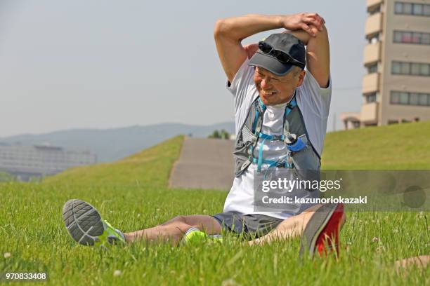 man stretching on grass - kazunoriokazaki stock pictures, royalty-free photos & images