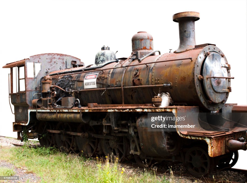 Old rusty steam locomotive with sign "Danger asbestos" white background