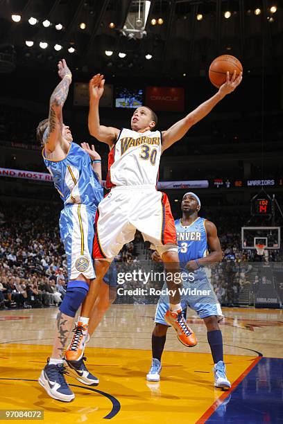 Stephen Curry of the Golden State Warriors attempts a layup after making contact with Chris Andersen of the Denver Nuggets on February 25, 2010 at...