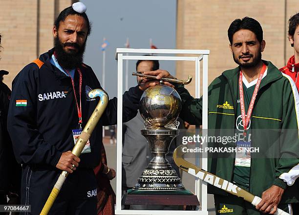 India hockey captain Rajpal Singh and Pakistan hockey captain Zeeshan Ashraf pose with the FIH Hockey World Cup 2010 trophy during a photo shoot in...