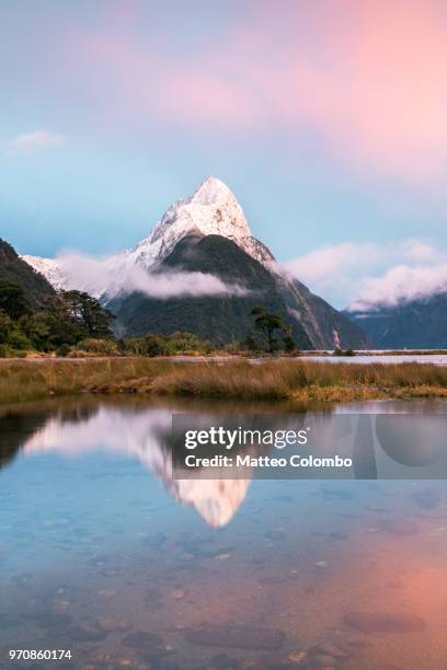 landscape: iconic view of milford sound at sunrise, new zealand - mitre peak stock pictures, royalty-free photos & images