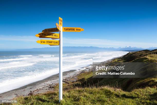 signpost near the coastline, south island, new zealand - south island new zealand fotografías e imágenes de stock