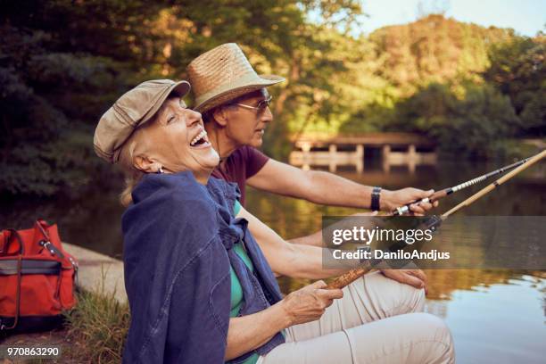hermosa pareja senior disfrutando de la pesca y la diversión - agua estancada fotografías e imágenes de stock