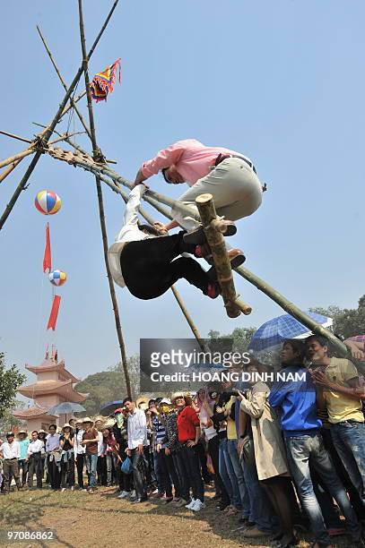 Couple stand on a swing at the Hoi Lim festival, popular for its Quan Ho folk music, in the northern province of Bac Ninh on February 26, 2010. Quan...