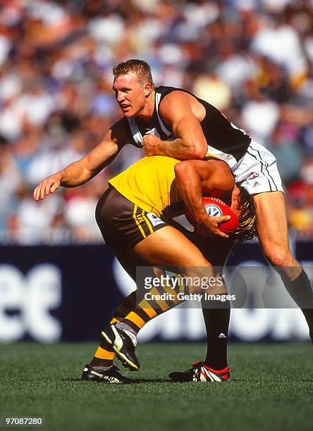 Daniel Chicks of the Hawks is tackled by Nathan Buckley of the Magpies during the round one AFL match between Collingwood and Hawthorn in Melbourne,...