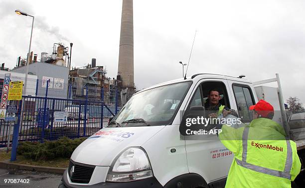 Worker from French trade-union CGT distributes leaflets in front of the US ExxonMobil refinery in Port-Jerome, western France, on February 23, 2010....