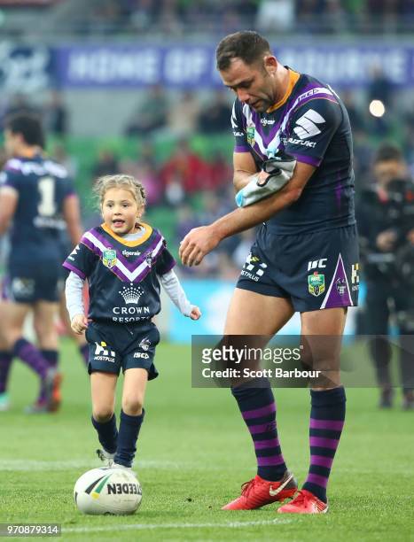 Cameron Smith of the Storm receives the kicking tee from his daughter and ball kid Matilda Smith during the round 14 NRL match between the Melbourne...