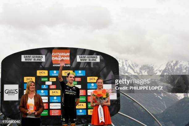 Great Britain's Adam Yates celebrates on the podium after winning the seventh and last stage of the 70th edition of the Criterium du Dauphine cycling...