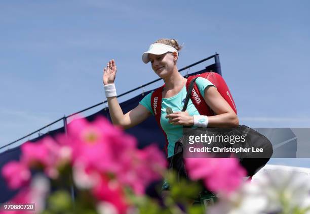 Alison Riske of USA waves to the crowd as she enters the court for her match against Conny Perrin of Switzerland during their Womens Final match on...