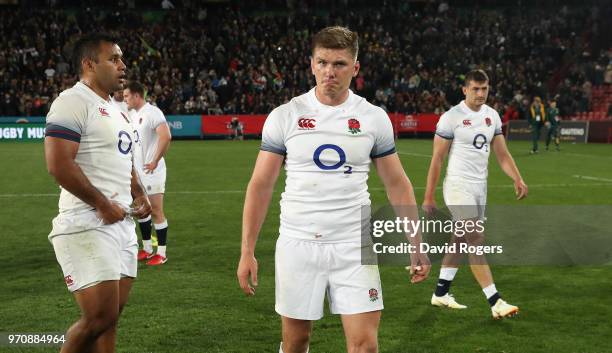 England captain, Owen Farrell, looks dejected as he walks off the field with team mates Billy Vunipola and Jonny May after their defeat during the...