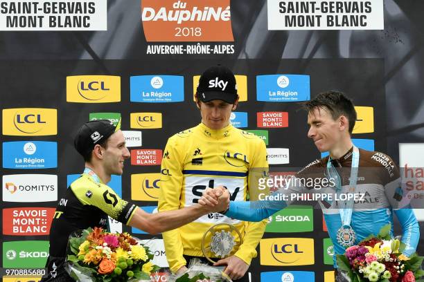 Stage winner and overall second-placed Great Britain's Adam Yates and third-placed France's Romain Bardet tap hands as they celebrate on the podium...