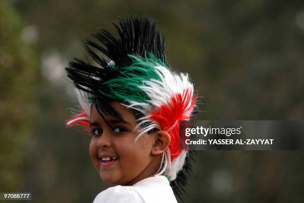 Kuwaiti girl wearing a wig in the colours of her national flag attends celebrations marking the Gulf emirate's national and liberation days in Kuwait...