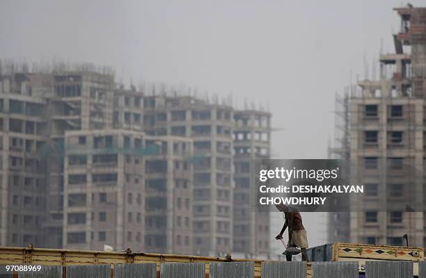 An Indian labourer offloads sand from a truck at a construction site at 'New Town' on the outskirts of Kolkata on February 26, 2010. India's economic...