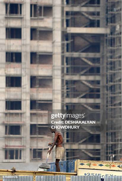 An Indian labourer offloads sand from a truck at a construction site at 'New Town' on the outskirts of Kolkata on February 26, 2010. India's economic...