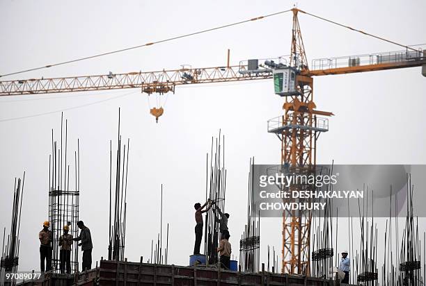 Indian labourers work at a construction site at 'New Town' on the outskirts of Kolkata on February 26, 2010. India's economic growth slowed sharply...