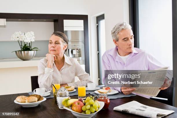 couple with newspaper at breakfast table - ignoring bildbanksfoton och bilder