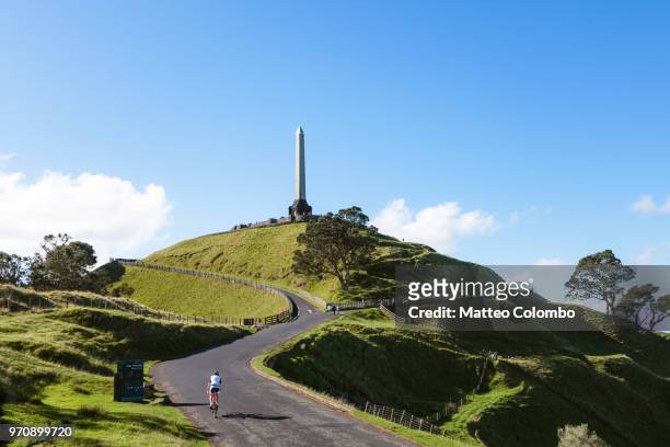 cyclist at one tree hill, auckland, new zealand - auckland stock pictures, royalty-free photos & images