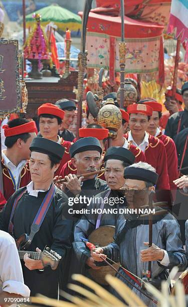 Men in traditional festive dress play music during a procession at Hoi Lim festival, popular for its Quan Ho folk music, in the northern province of...