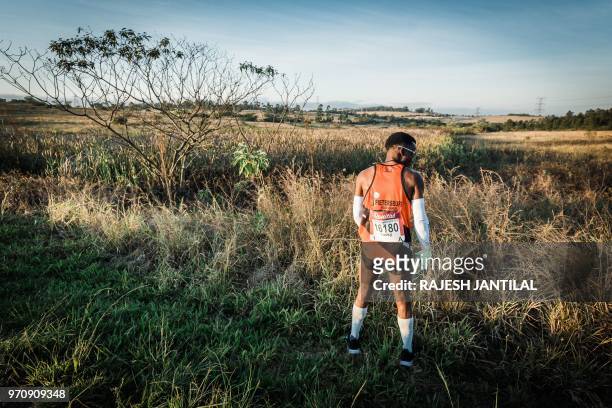 Runner takes a toilet break during the 89km Comrades Marathon between Pietermaritzburg and Durban on June 10, 2018.The annual ultra marathon this...