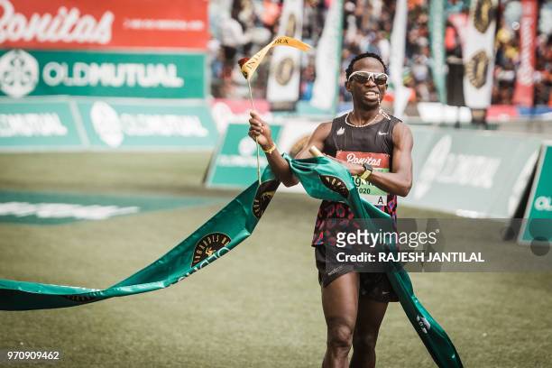 South African long-distance runner Bongmusa Mthembu reacts after passing the finish line and winning the 89km Mens Comrades Marathon between...