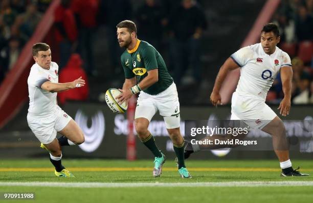 Willie le Roux of South Africa off loads the ball watched by George Ford and Billy Vunipola during the first test match between South Africa and...