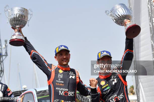 Belgium's driver Thierry Neuville and compatriot co-driver Nicolas Gilsoul of Hyundai i20 Coupe WRC, hold their trophies as they celebrate on the...