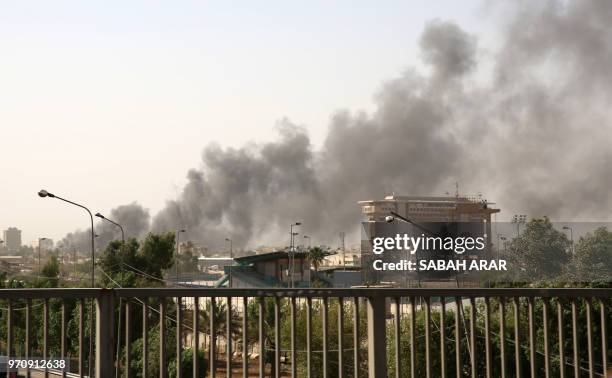 Picture taken on June 10, 2018 shows a smoke plume billowing across the skyline of the Iraqi capital Baghdad from a fire in the country's biggest...