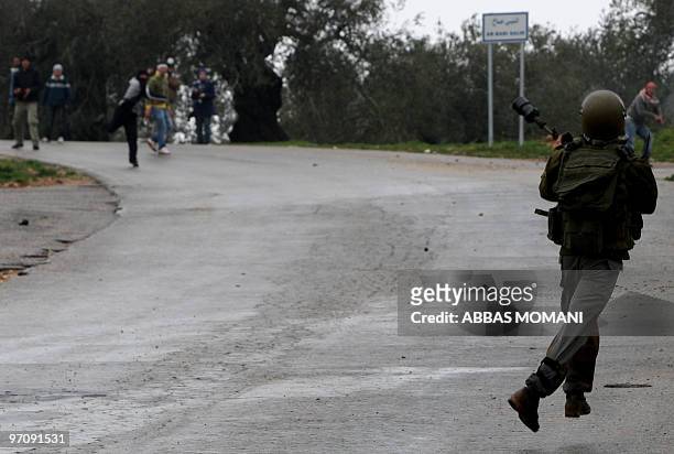 Palestinian demonstrator throws a stone towards an Israeli soldier during clashes in the village of Nabi Saleh, near Ramallah, following a protest on...