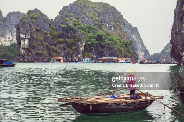 woman on rowing boat in floating fisher village in halong bay, vietnam - quang ninh stock pictures, royalty-free photos & images