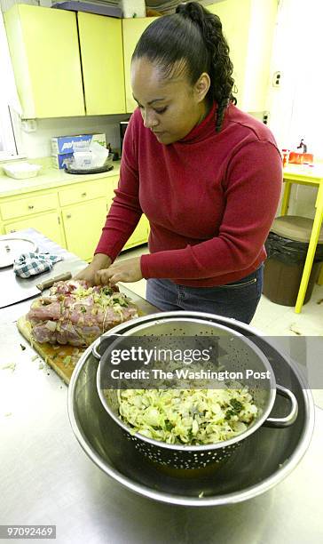 Sm_ham 12-18-04 St. George Island, Md Mark Gail/TWP Nicole Faulkner of Glen Burnie stuffs her ham for her first try at a Southern Maryland favorite...