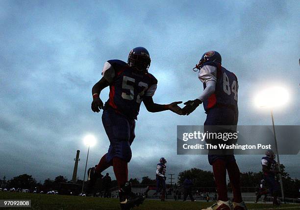 Josua Young, left, and Emani Lee of Anacostia take the field before playing Ballou High School at Anacostia's brand new stadium.