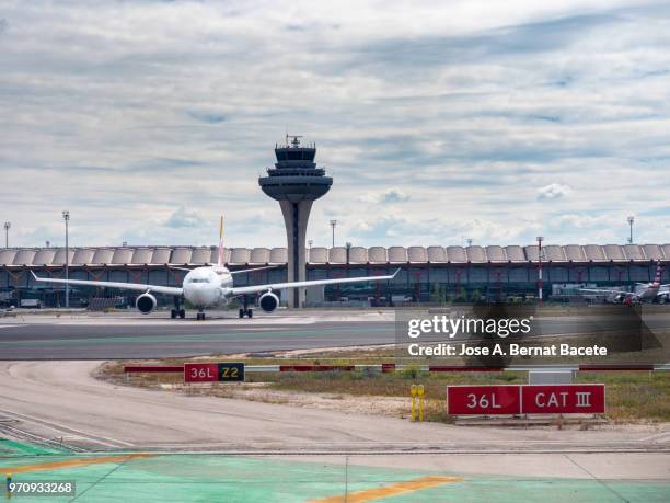 terminal building and tower of control of the airport with planes in the track. madrid, spain. - lax stockfoto's en -beelden