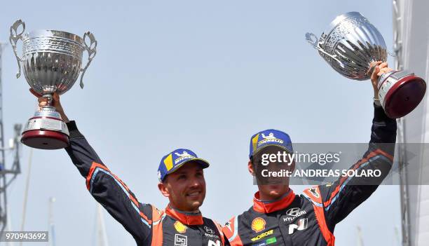 Belgium's driver Thierry Neuville and compatriot co-driver Nicolas Gilsoul of Hyundai i20 Coupe WRC, hold their trophies as they celebrate on the...