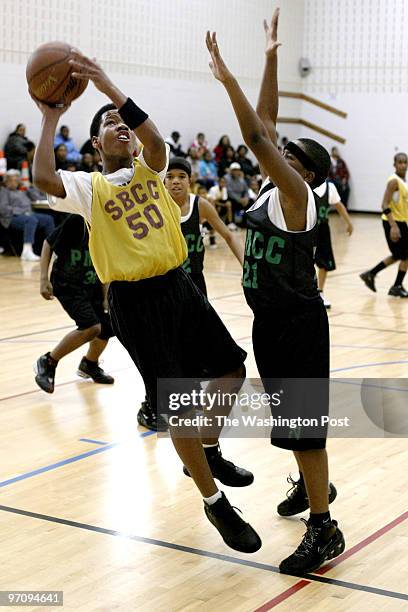 Pg-cover24 03-19-05 Mark Gail_TWP South Bowie Community Center's Timothy Fitzgerald looks to shoot over Peppermill Community Center's Jerone Tyler in...