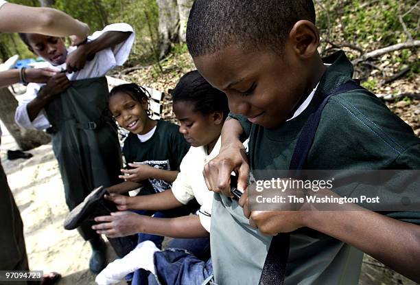 Dc-cover5-12 04-21-05 Mark Gail_TWP Fourth graders, Johnnie Bailey, Monique Edwards taking off her shoes, as Veronica Gyebi looks on and Tysean...