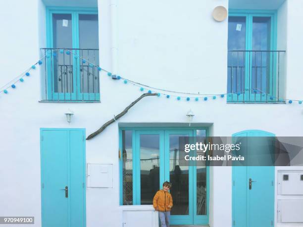 boy in front of mediterranean house - isabel pavia stockfoto's en -beelden