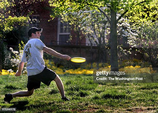 Me-WeatherFun Photos by Michael Williamson NEG#00000 4/18/06 -- Ralph Camardo of Annapolis enjoys a Frisbee game with some pals on the lawn at St....