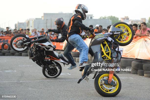 Indian professional stuntmen perform on motorbikes during the KTM stunt show in Amritsar on June 10, 2018.