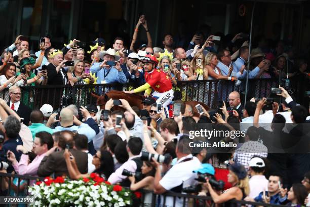 Jockey Mike Smith reacts atop of Justify the 150th running of the Belmont Stakes at Belmont Park on June 9, 2018 in Elmont, New York. Justify becomes...