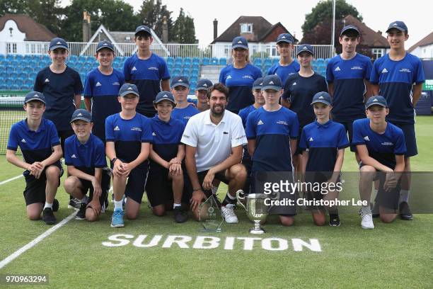 Jeremy Chardy of France poses for the camera with the Surbiton Trophy and the ball kids after his victory over Alex De Minaur of Australia during...