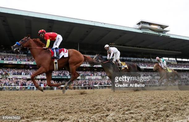 Justify, ridden by jockey Mike Smith crosses the finish line to win the 150th running of the Belmont Stakes at Belmont Park on June 9, 2018 in...