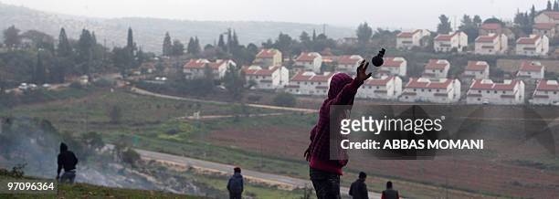 Palestinian protester trows an unexploded tear gas grenade back towards Israeli troops during clashes in the village of Nabi Saleh, near Ramallah,...