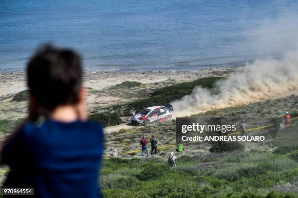 Boy looks at the Toyota Yaris WRC of Estonian driver Ott Tanak and his co-driver Martin Jarveoja, during the 2018 FIA World Rally Championship on...