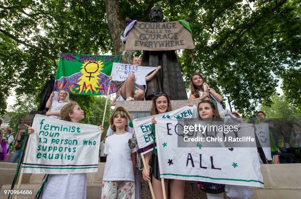 Group of girls pose for photographs for their mothers next to a statue of Millicent Fawcett in Parliament Square after taking part in mass...