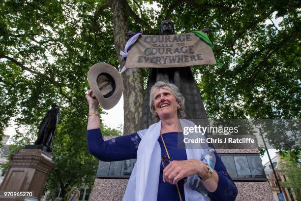 Woman poses for photographs next to a statue of Millicent Fawcett in Parliament Square after taking part in mass participation artwork 'Processions'...