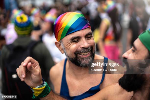 mature gay couple dancing on gay pride parade - go go dancer stock pictures, royalty-free photos & images